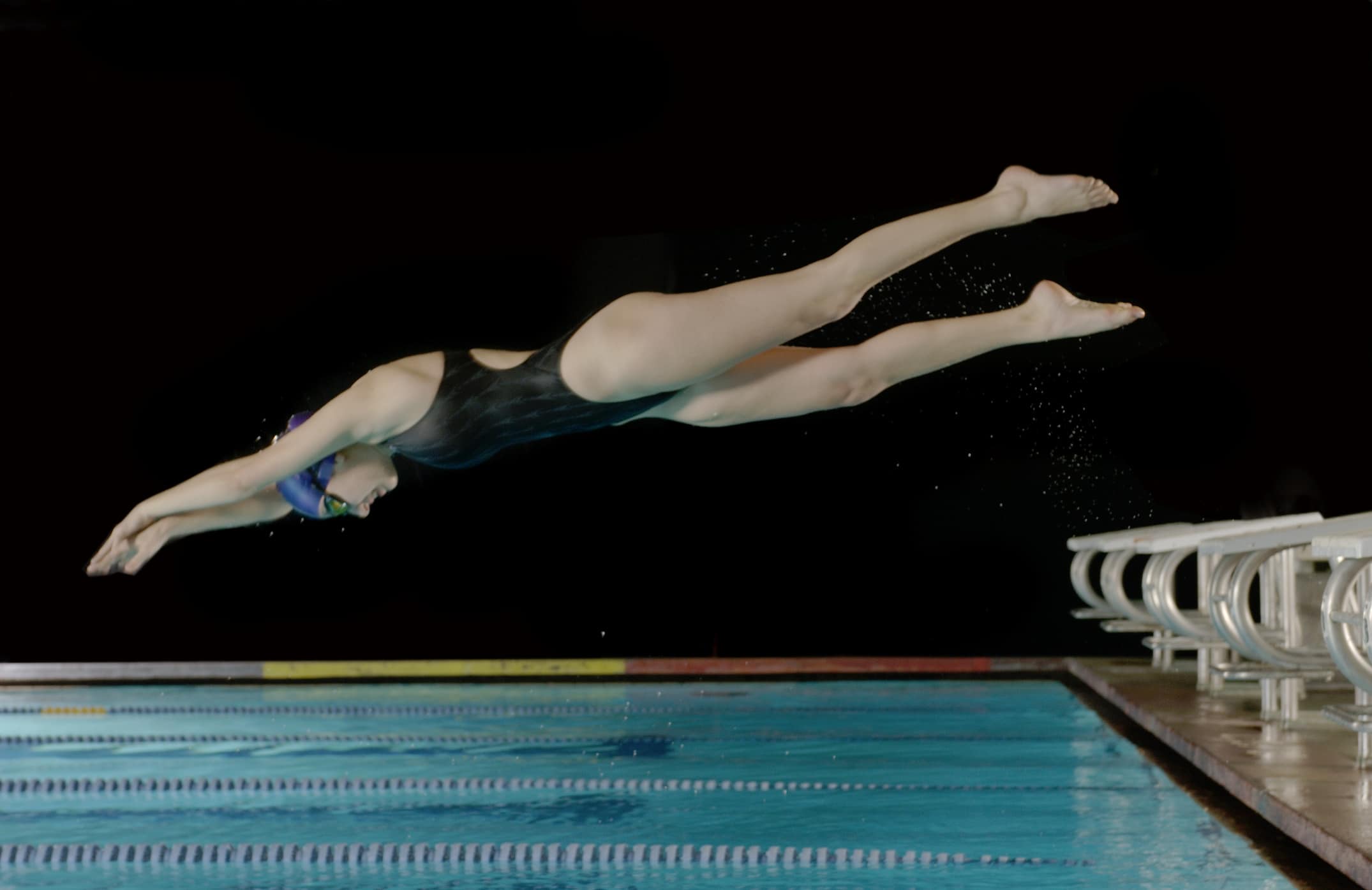 Female swimmer diving in mid-air