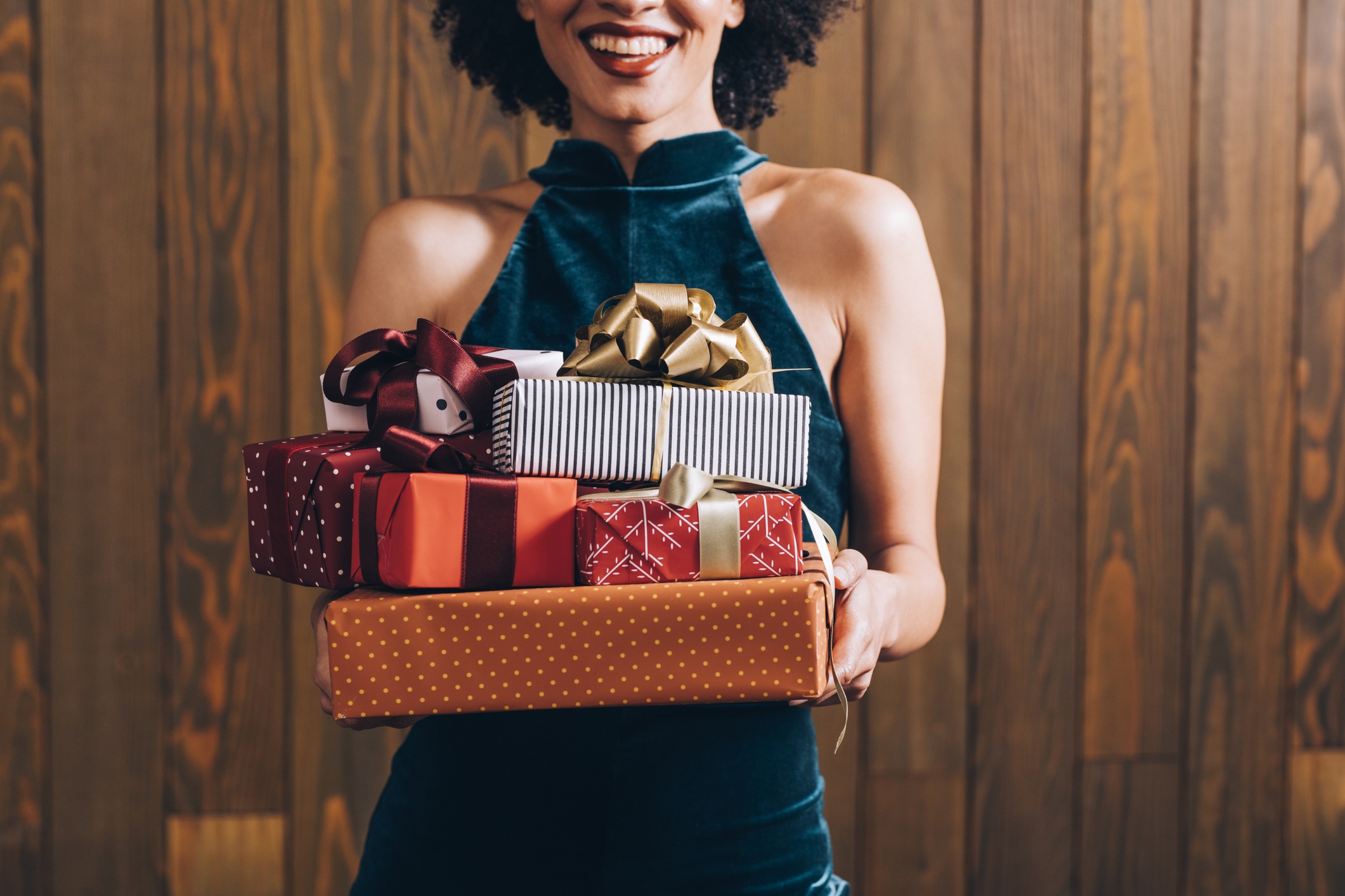 Merry Christmas: a n Anonymous Smiling Elegant African American Woman Holding a Pile of Presents in her Hands, a Close Up