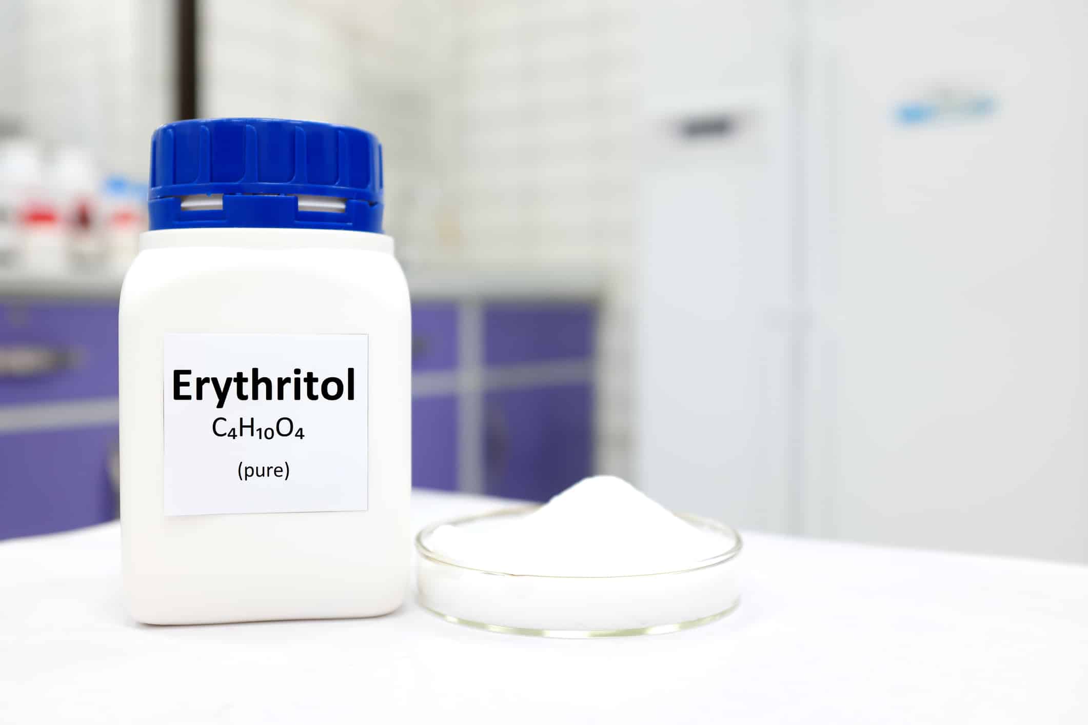 Selective focus of a bottle of pure erythritol artificial sweetener sugar substitute. White laboratory background with copy space.