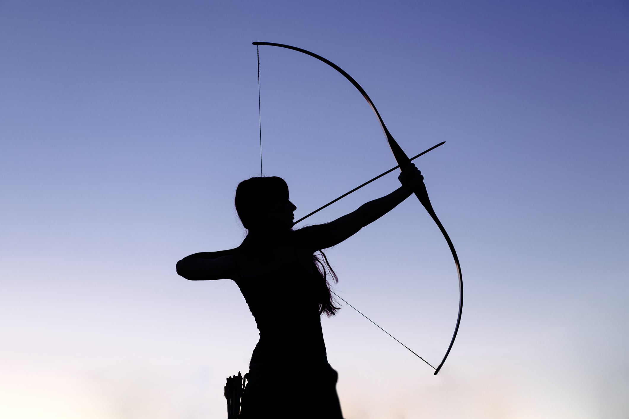 Female ginger hair archer shooting targets with her bow and arrow. Concentration, target, success concept