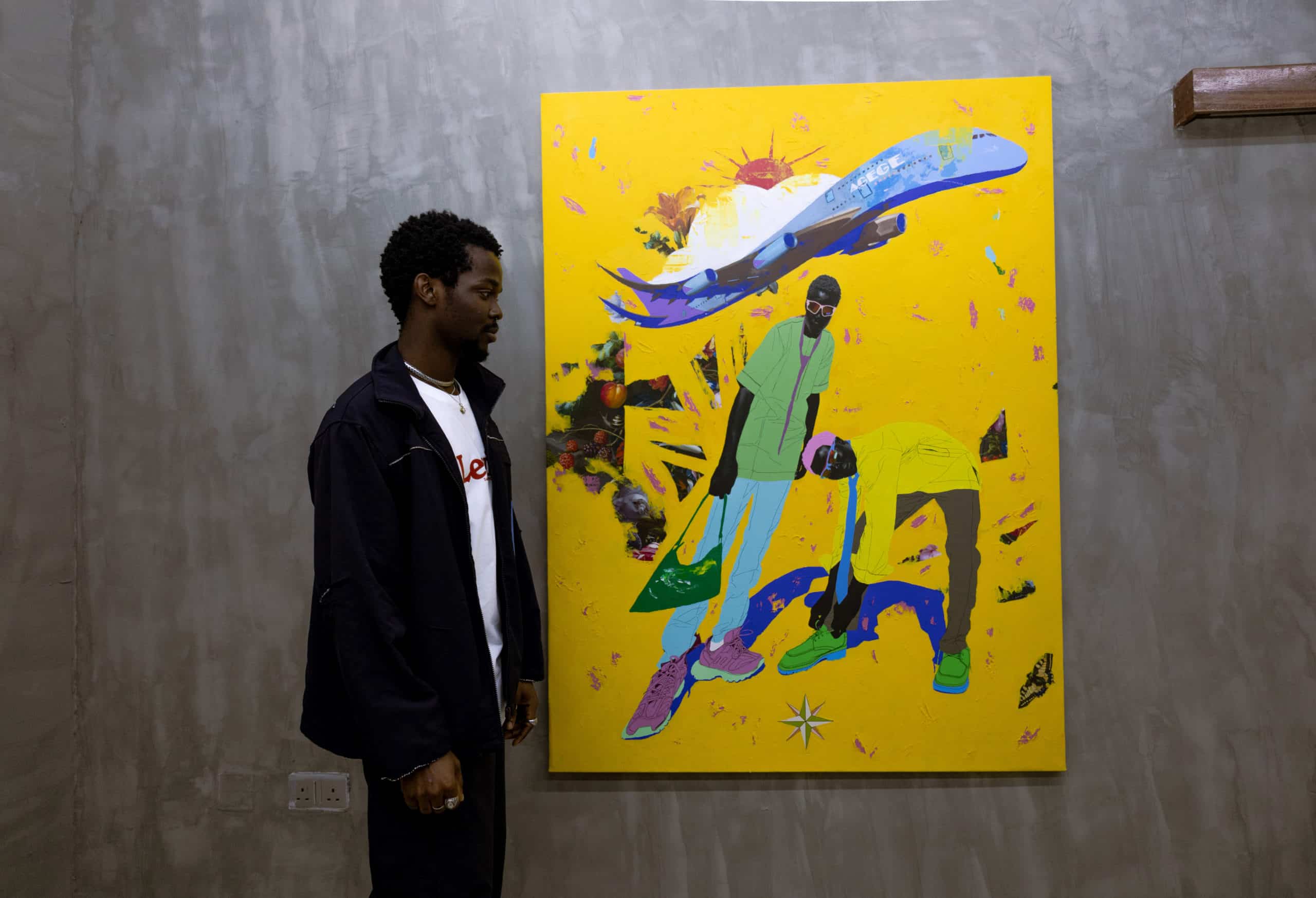 Adesola Yusuf posing with one of his artworks