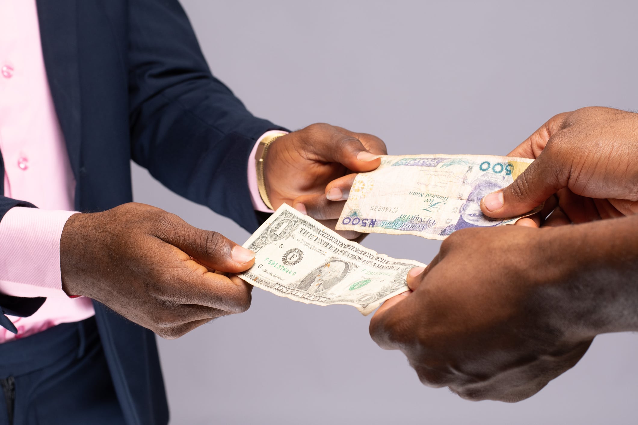 Closeup shot of two person trading Nigerian naira and US dollar