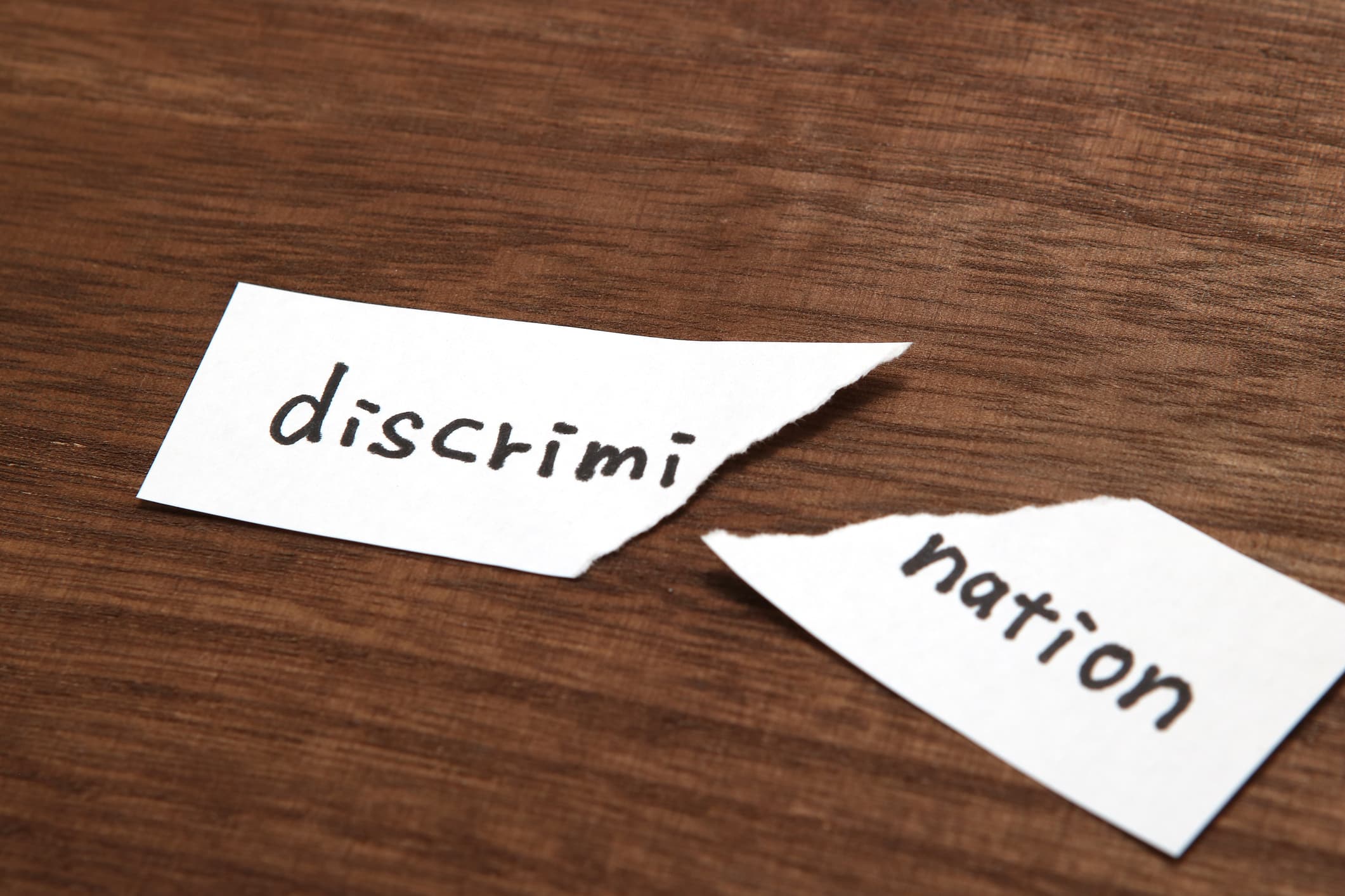 The paper written as discrimination is torn on wood. Concept of abolition of discrimination.