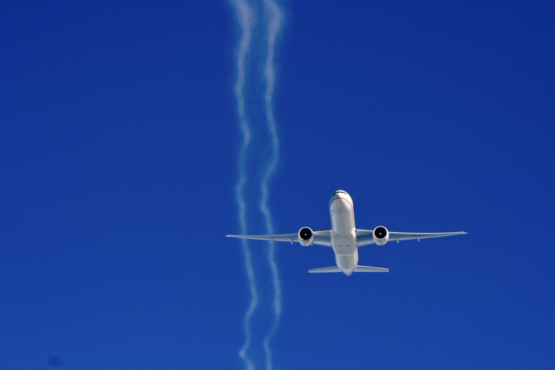 Etihad Boeing 777 with contrails on blue