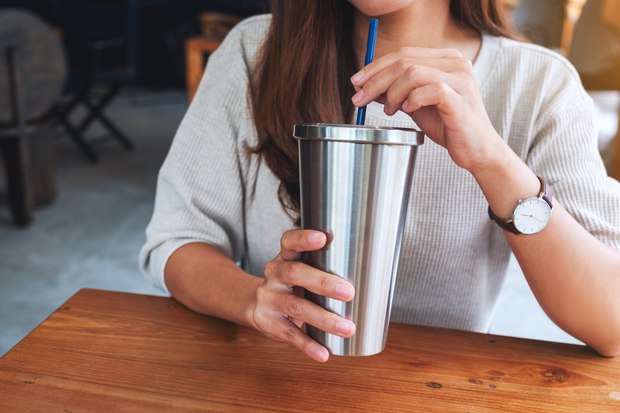 a woman drinking coffee in stainless steel cup