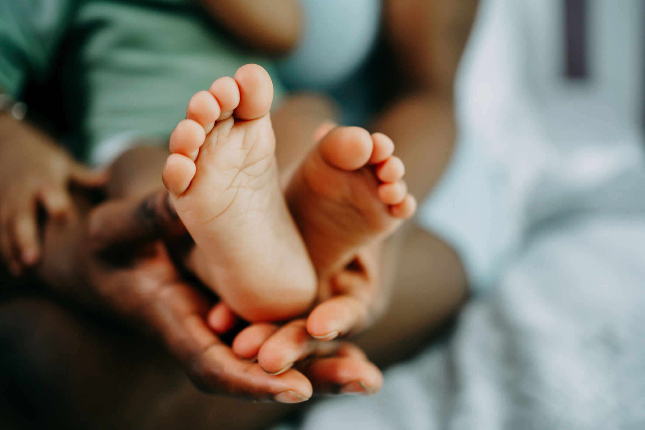 Mother’s hand holds black baby’s leg close-up